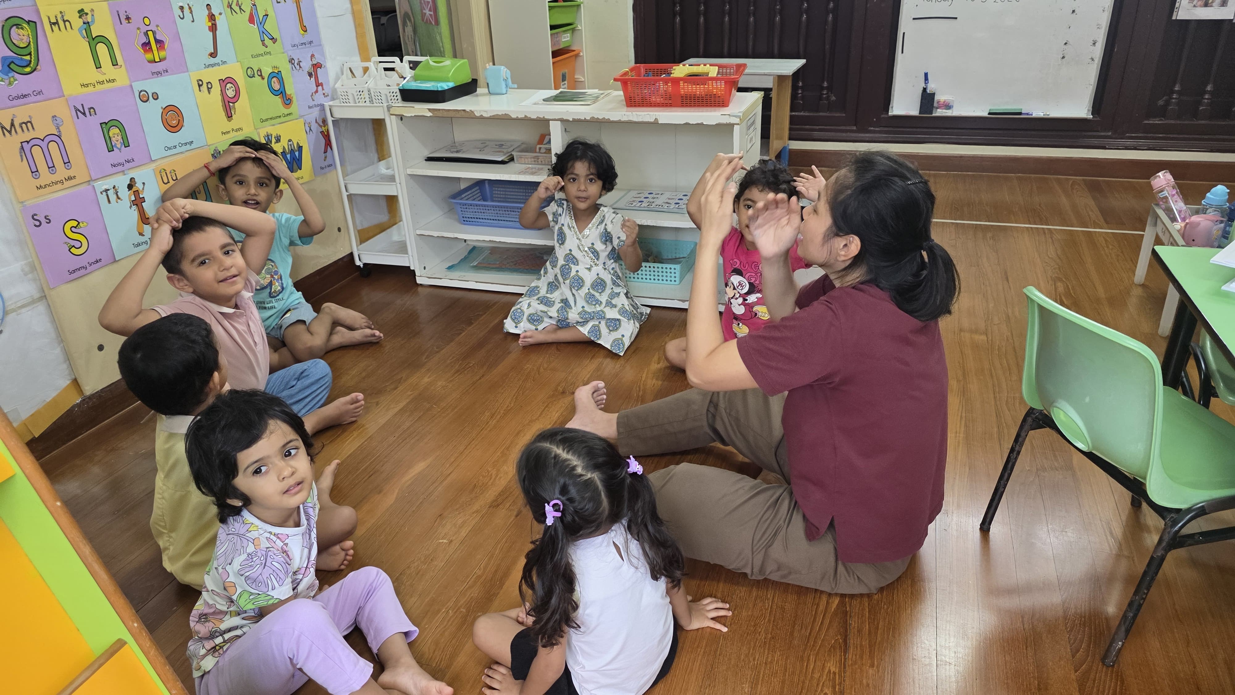 Educator at Genius Gems Childcare Centre guiding children through a bilingual English and Mandarin learning activity